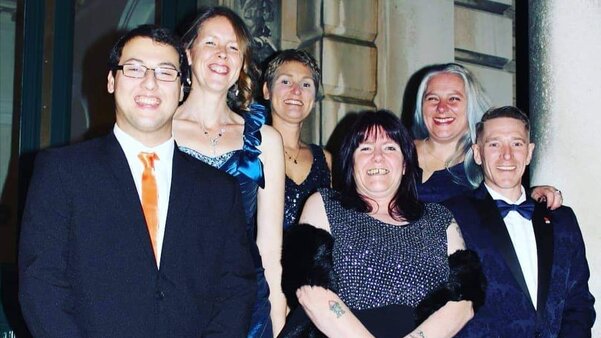 Six people in formal attire standing on some steps