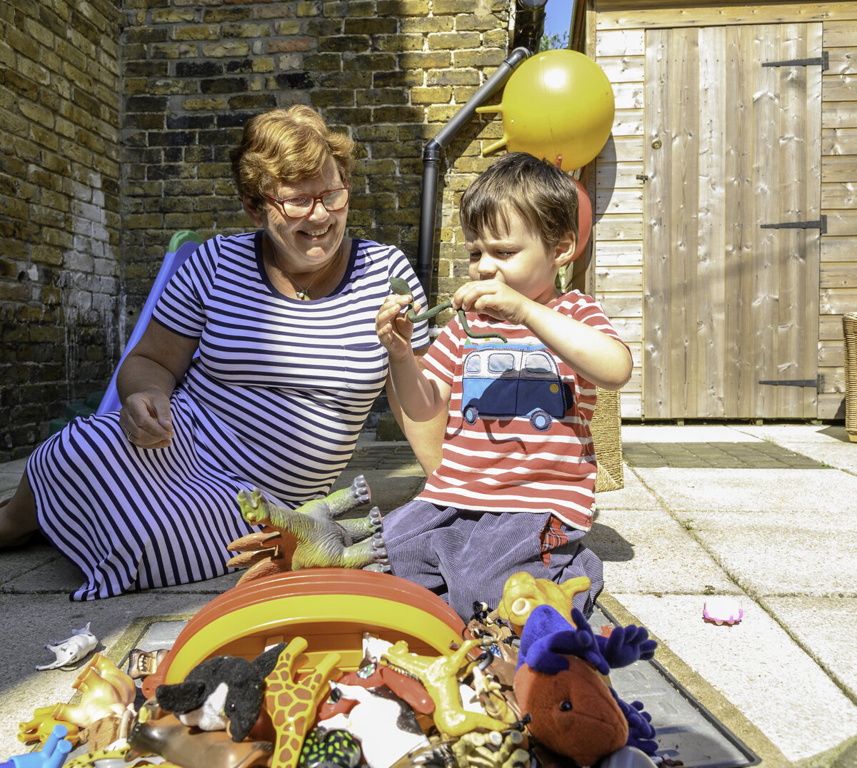 Young boy playing outside with toys